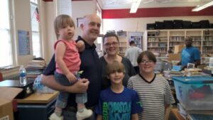 Joshua Z and his family help with cleaning the library of the Capital Heights Middle School