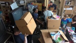 Volunteers moving and organizing boxes at Capital Heights Middle School