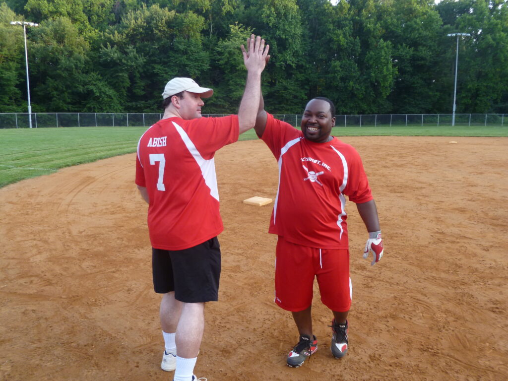 ActioNeters Jeff A. and Tyreace R. High Five on the Softball Field to Celebrate Great Teamwork