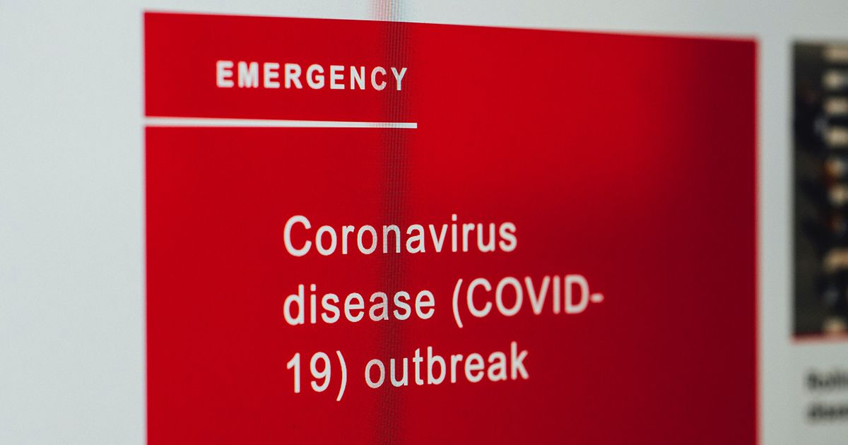 A red sign reading 'Coronavirus disease (COVID-19) outbreak'