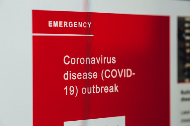 A photograph of a sign reading 'Emergency Coronavirus disease (COVID-19) outbreak"