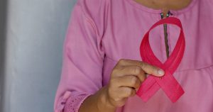 Woman holding a breast cancer awareness ribbon